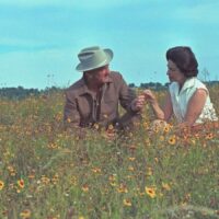 President Lyndon B. Johnson and First Lady “Lady Bird” Johnson sitting in a field of flowers.