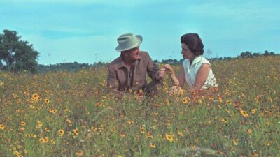 President Lyndon B. Johnson and First Lady “Lady Bird” Johnson sitting in a field of flowers.