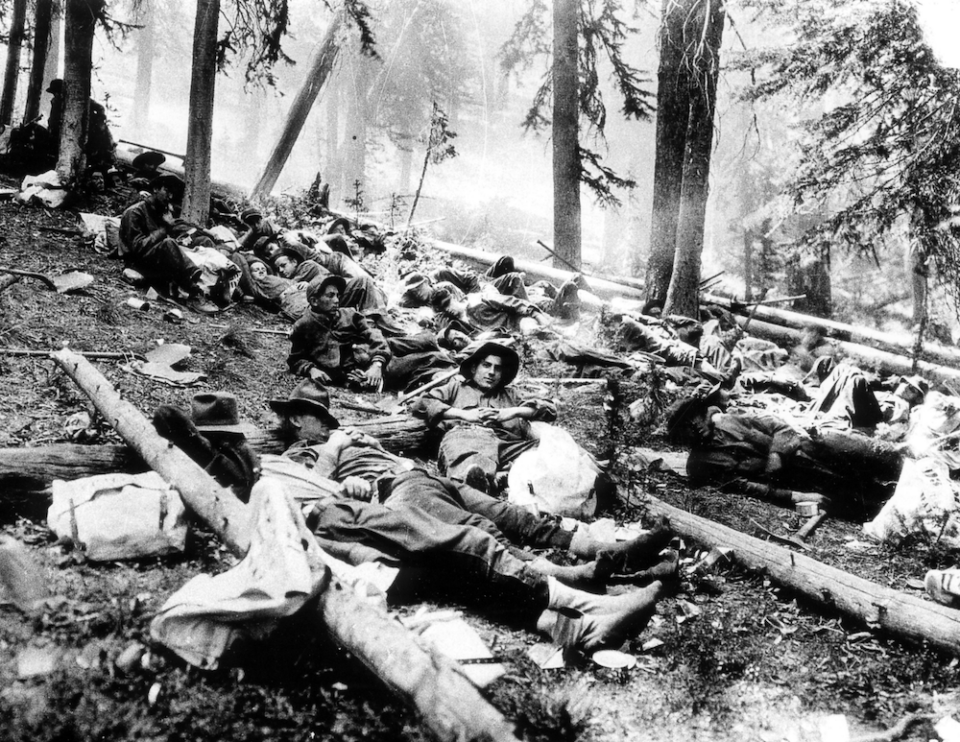 Black and white photo of CCC fire fighters resting.